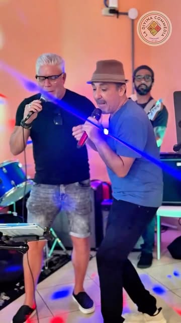 Foto real del cantante y la banda en vivo, con luces de escenario, en La Divina Commedia Coronado