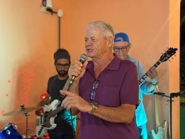 Foto real del cantante principal cantando de cerca junto a la banda en La Divina Commedia Coronado